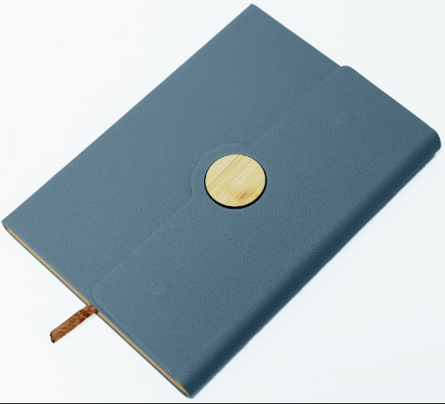 Custom laser-engraved A5 leatherette notebook with circular bamboo emblem badge by Print365 Kenya