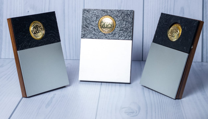 Custom laser-engraved silver and wood plaque award with black textured header band by Print365 Kenya
