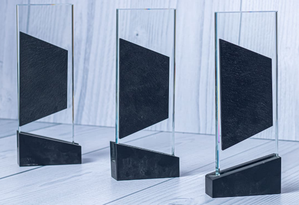 Custom laser-engraved clear glass award with asymmetrical dark slate center panel by Print365 Kenya