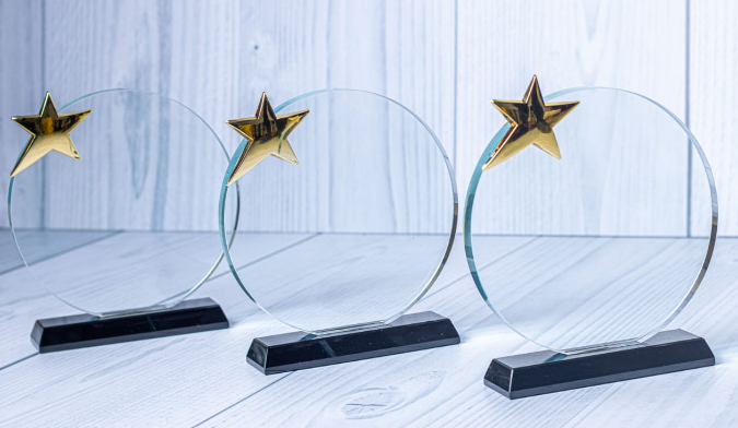 Custom laser-engraved circular crystal award trophy with gold star accent by Print365 Kenya
