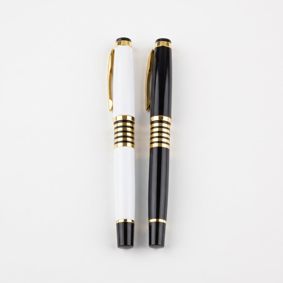 Custom laser-engraved executive black and white metal pens with striped gold trim by Print365 Kenya