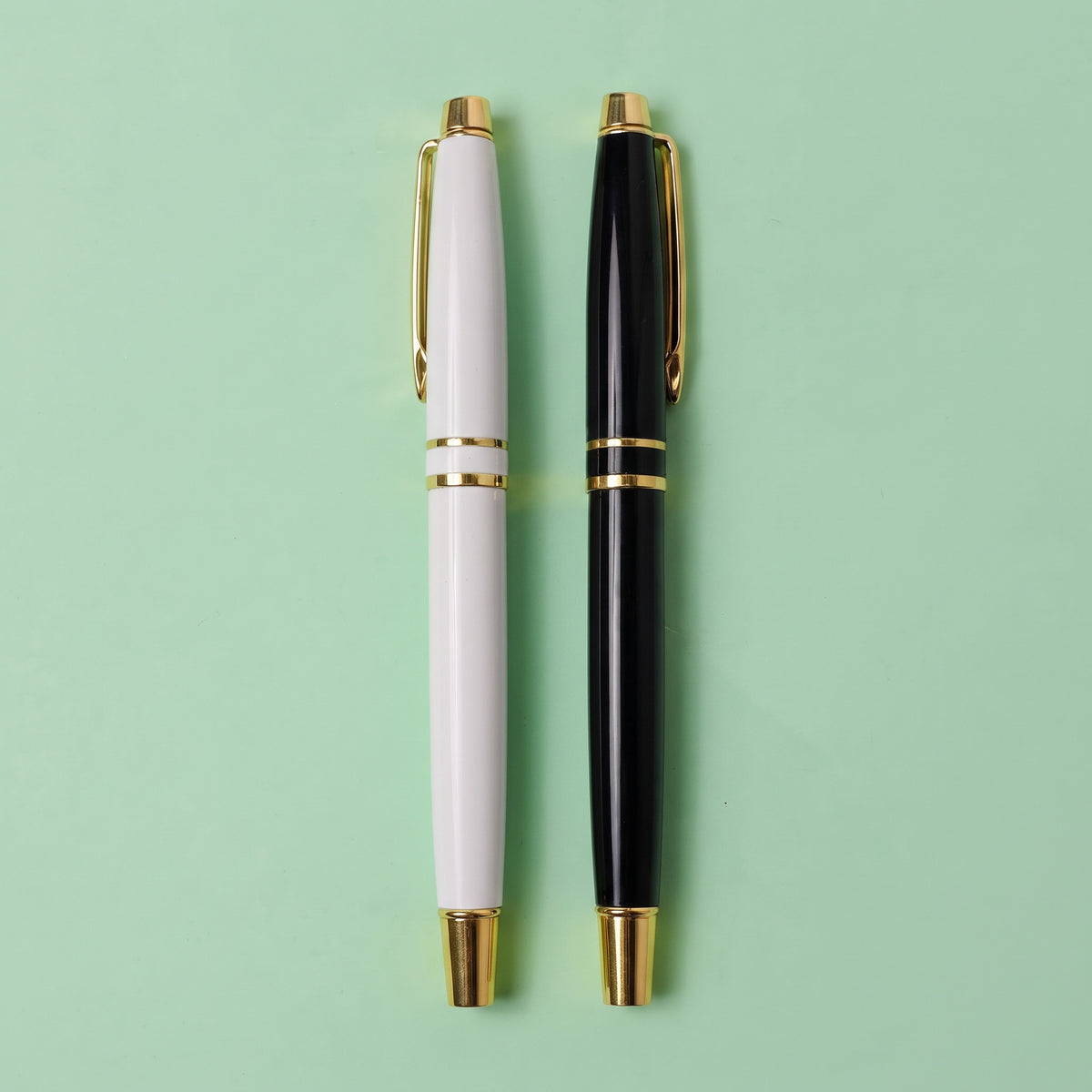 Custom laser-engraved executive white and black metal pens with gold trim accents by Print365 Kenya