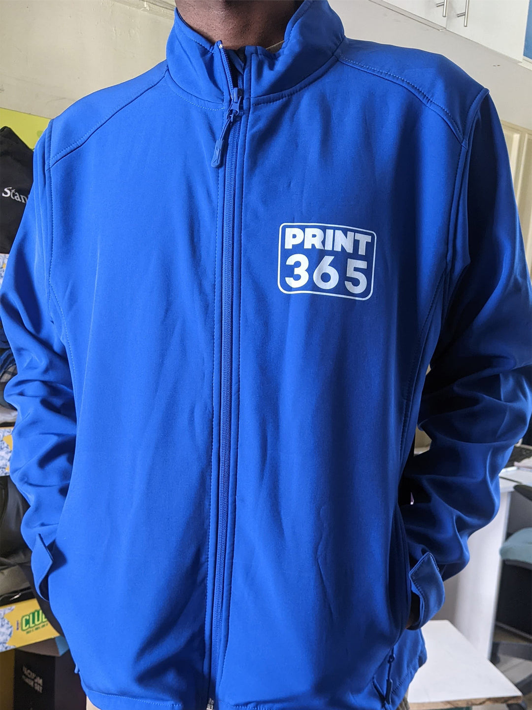 Person wearing a blue jacket with &