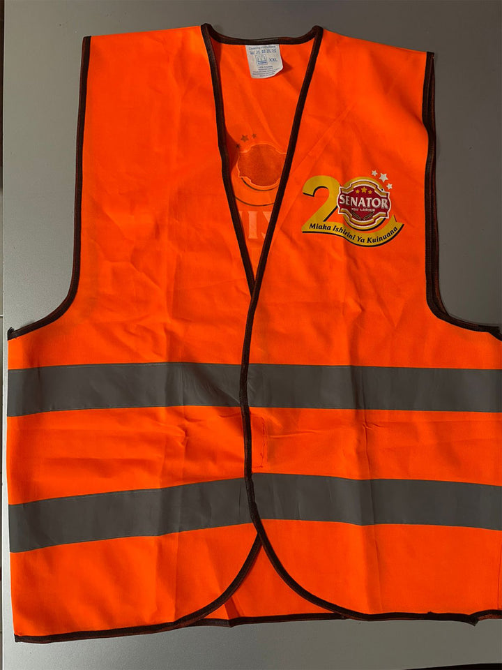 Orange safety vest with reflective stripes and a logo on a gray background