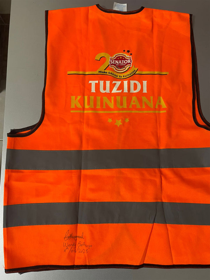 Orange safety vest with reflective stripes and printed text on a gray background