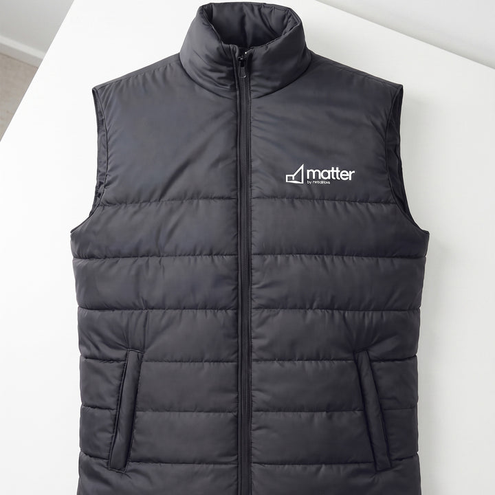Custom black quilted puffer vest with a stand-up collar and front zipper done in Nairobi, Kenya