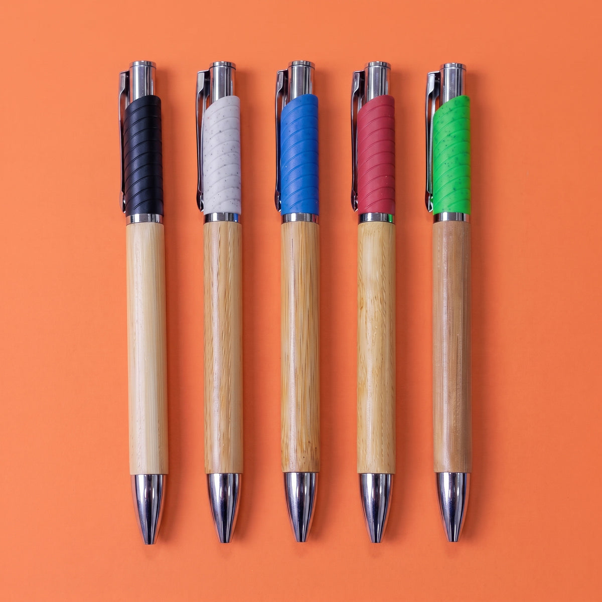 Custom laser-engraved bamboo wooden pens with colored spiral upper grips by Print365 Kenya