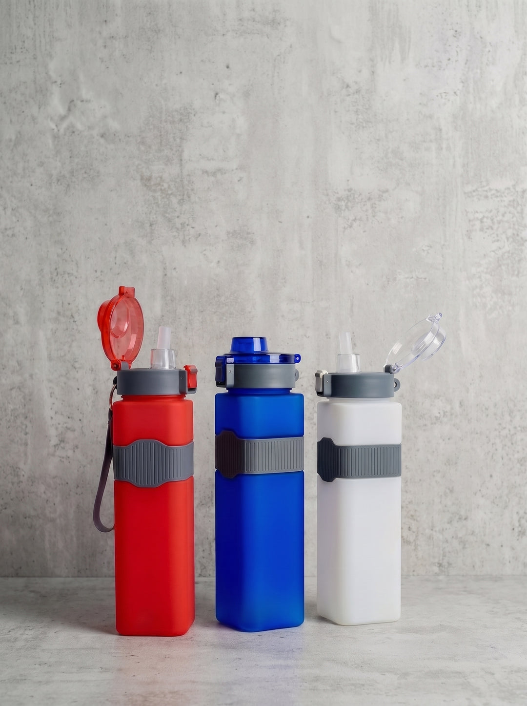 Three reusable water bottles in red, blue, and white with gray flip-top lids and gray bands done by Print365 Kenya