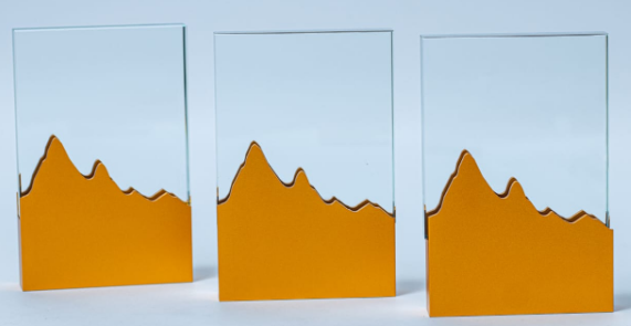 Custom laser-engraved clear glass award trophy with yellow gold mountain range base by Print365 Kenya