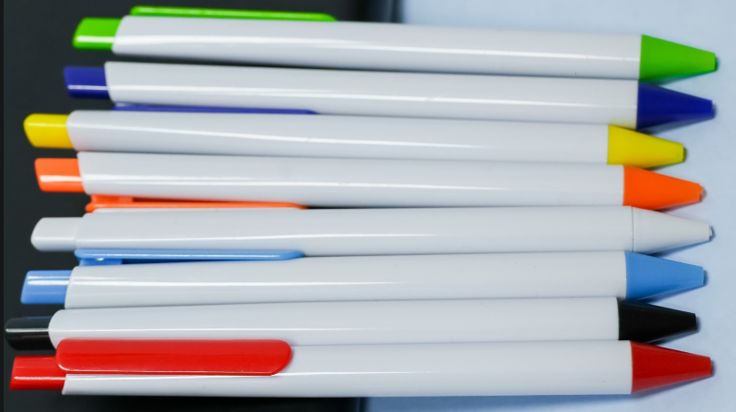 Custom printed white plastic promotional pens with color-coded tips and clip accents by Print365 Kenya