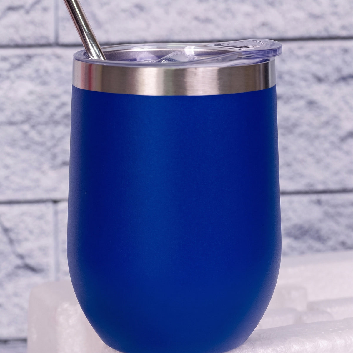 A custom matte blue insulated tumbler with a stainless steel rim, clear lid, and metal straw done in Nairobi Kenya