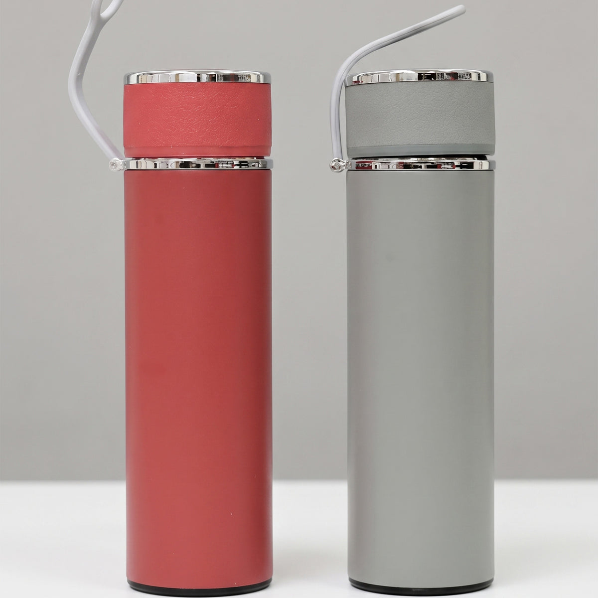 Two custom matte insulated tumblers with carrying loops in coal red and light grey done in Nairobi Kenya