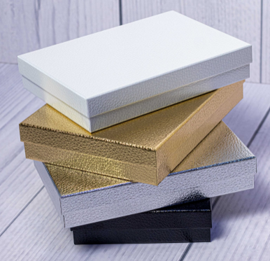 Custom foil-stamped nested stairs gift boxes stacked in white, gold, silver, and black by Print365 Kenya