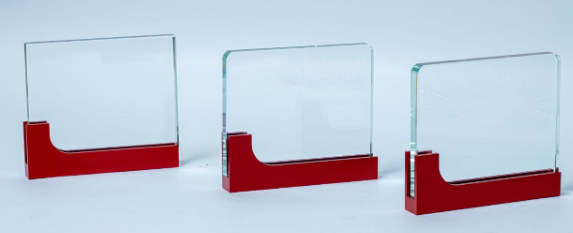 Custom laser-engraved clear acrylic award trophy with bold red geometric base by Print365 Kenya