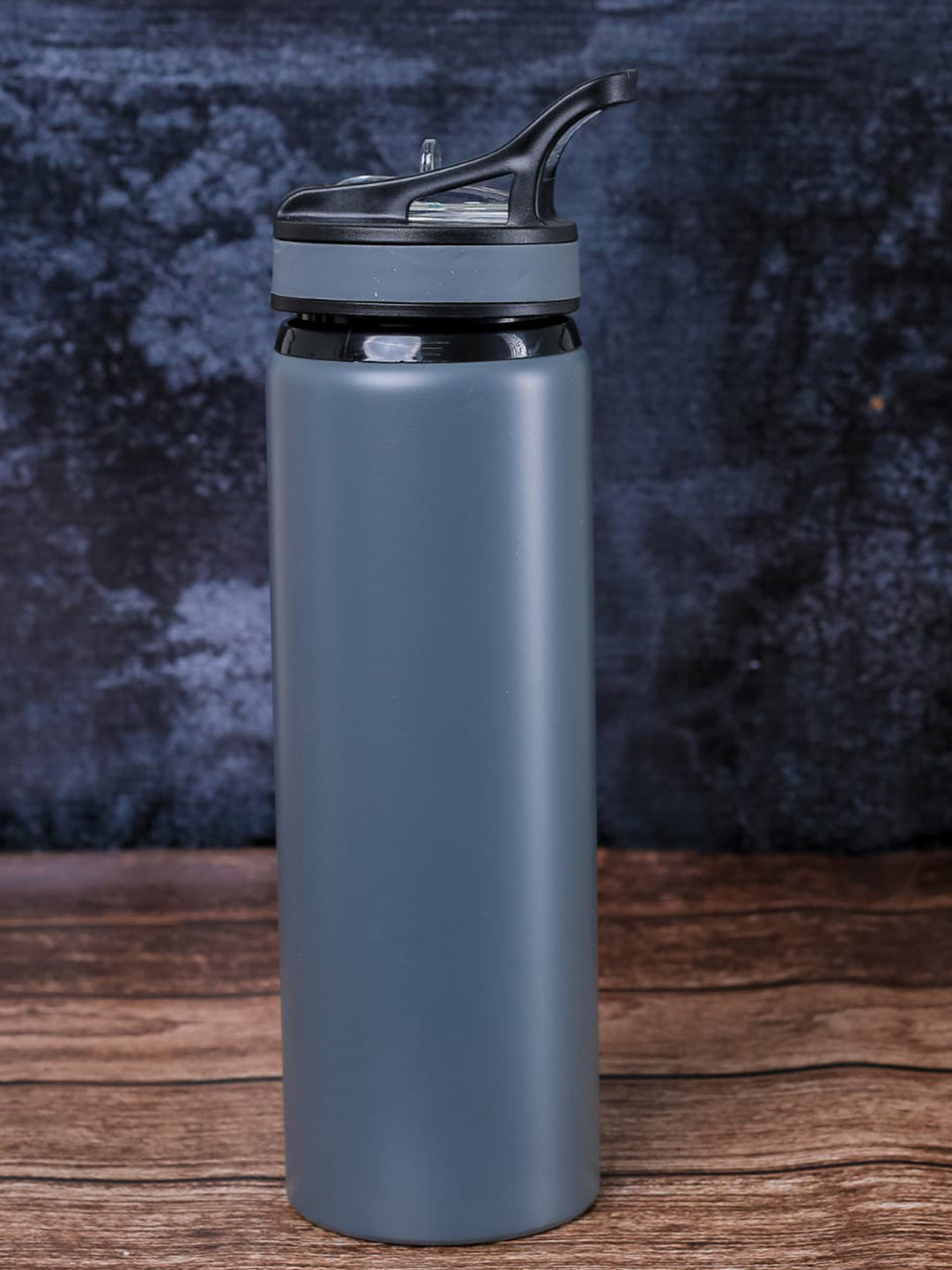 A custom metal matte slate blue water bottle with a black flip-top lid done in Nairobi Kenya